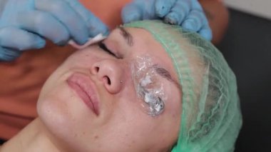 Kalıcı bir makyöz, bir kadının göz kapaklarına dövme yaptırır..