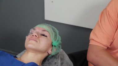 Kalıcı bir makyöz, bir kadının göz kapaklarına dövme yaptırır..