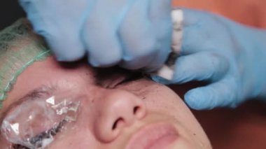 Kalıcı bir makyöz, bir kadının göz kapaklarına dövme yaptırır..