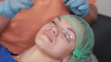 Kalıcı bir makyöz, bir kadının göz kapaklarına dövme yaptırır..