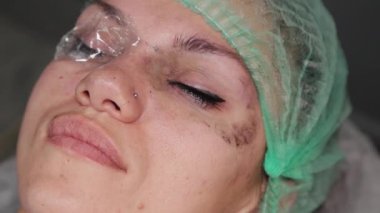 Kalıcı bir makyöz, bir kadının göz kapaklarına dövme yaptırır..