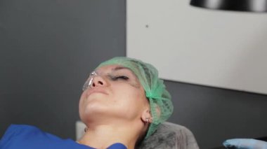 Kalıcı bir makyöz, bir kadının göz kapaklarına dövme yaptırır..