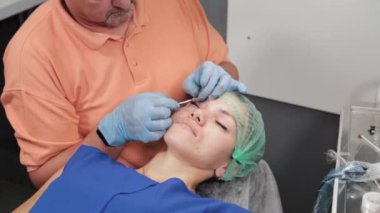 Kalıcı bir makyöz, bir kadının göz kapaklarına dövme yaptırır..