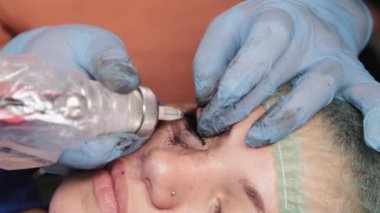 Kalıcı bir makyöz, bir kadının göz kapaklarına dövme yaptırır..