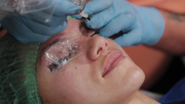 Un truccatore permanente si fa tatuare sulle palpebre superiori di una donna. — Video Stock