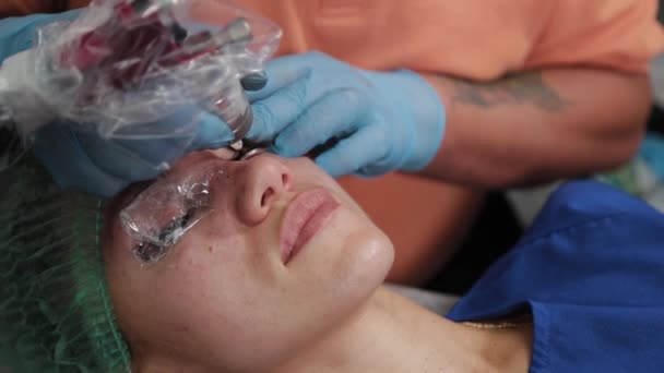 Stały makijażysta robi tatuaż kobietom na górnej powiece. — Wideo stockowe