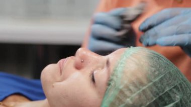 Kalıcı bir makyöz, bir kadının göz kapaklarına dövme yaptırır..