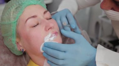 Doktor kozmetik uzmanı kadına dudak büyütme ameliyatı yapıyor..