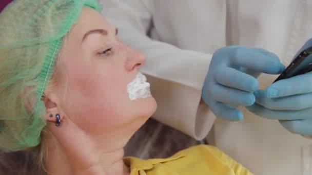 Belle femme avec gel anesthésique sur ses lèvres avant la procédure d'augmentation des lèvres. — Video