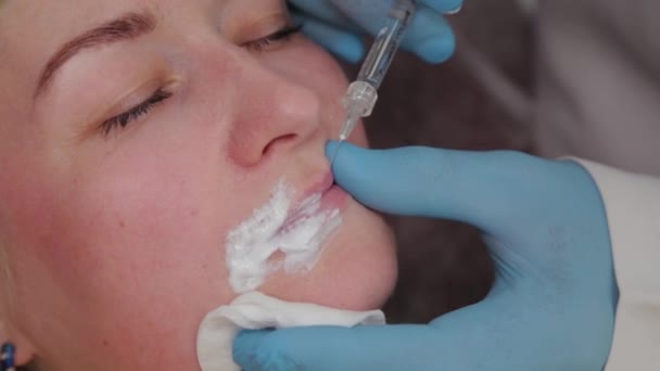 Doctor cosmetologist makes lip augmentation to woman. — Stock Video