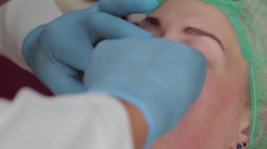 Doktor kozmetik uzmanı kadına dudak büyütme ameliyatı yapıyor..