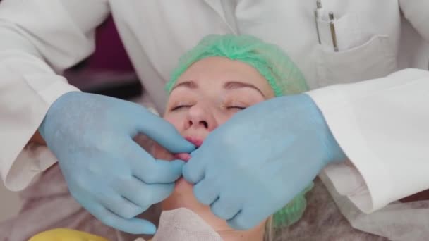 Doctor cosmetoloog maakt lip vergroting van de vrouw. — Stockvideo