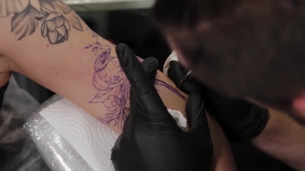 Dövme sanatçısı genç bir kızın kolunda dövme yapıyor.. — Stok video