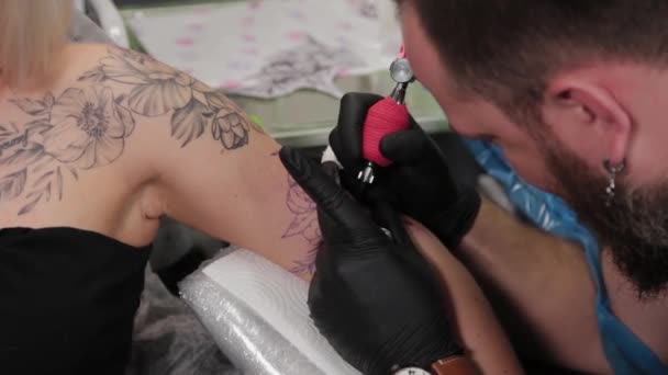 Tatuaggio artista fa un tatuaggio su un braccio di giovani ragazze. — Video Stock