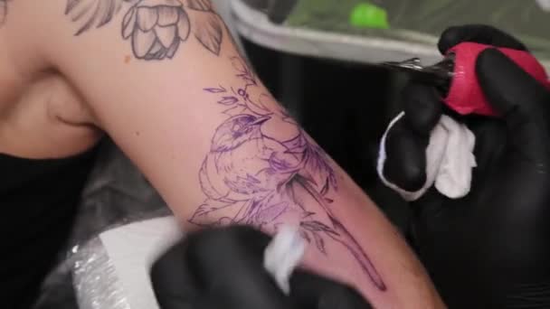 Tatueringsartist gör en tatuering på en ung flickas arm. — Stockvideo