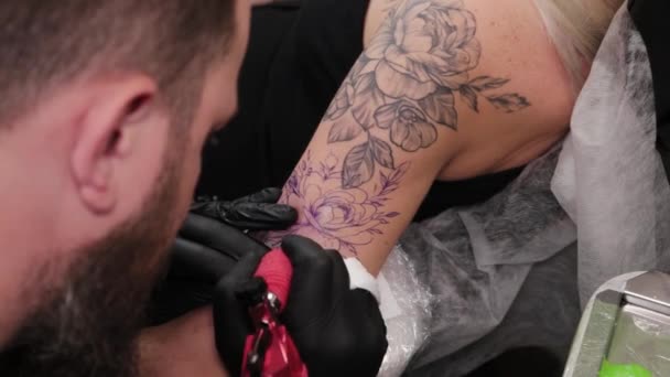 Художник татуювання робить татуювання на руці молодих дівчат . — стокове відео
