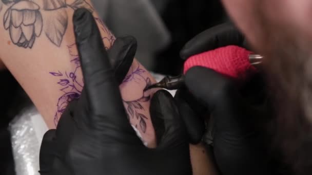 Tatuaje artista hace un tatuaje en un joven niñas brazo. — Vídeo de stock