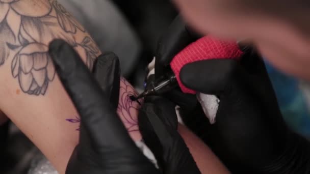 Tattoo artist makes a tattoo on a young girls arm. — Stock Video