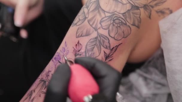 Tatuagem artista faz uma tatuagem em um braço de meninas jovens. — Vídeo de Stock