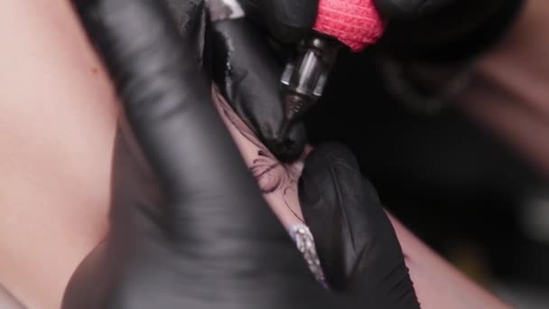 Tattoo artiste fait un tatouage sur un bras de jeunes filles. — Video