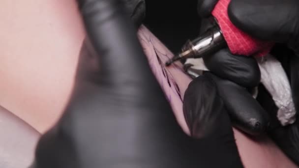 Tattoo artist makes a tattoo on a young girls arm. — Stock Video