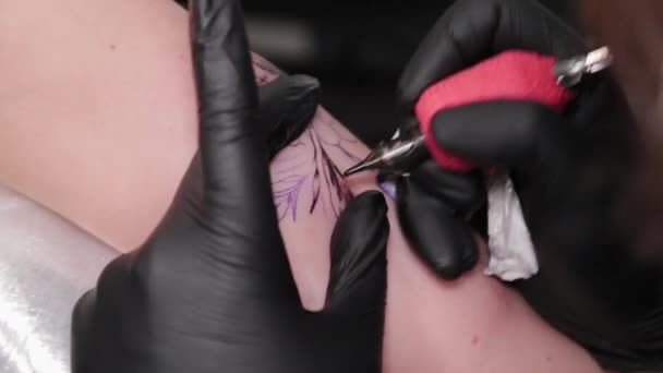 Tattoo artist makes a tattoo on a young girls arm. — Stock Video