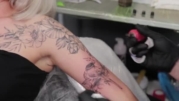 Tatuaje artista hace un tatuaje en un joven niñas brazo. — Vídeos de Stock