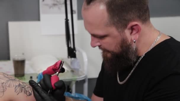 Tatuaje artista en el trabajo en un salón de tatuajes. — Vídeos de Stock