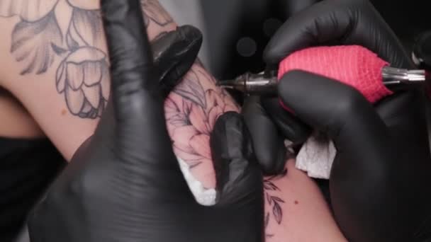 Tatuaż artysta robi tatuaż na ręce młodych dziewczyn. — Wideo stockowe