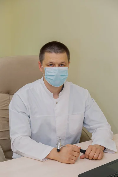 Médico varón con máscara protectora en el consultorio. — Foto de Stock