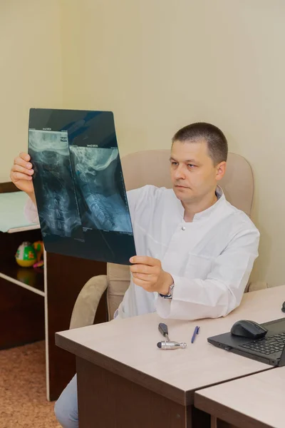Médecin neurologue masculin avec une image radiographique dans ses mains. — Photo