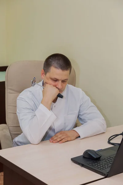 Doctor male neurologist pondering at his desk. — Stock Photo, Image