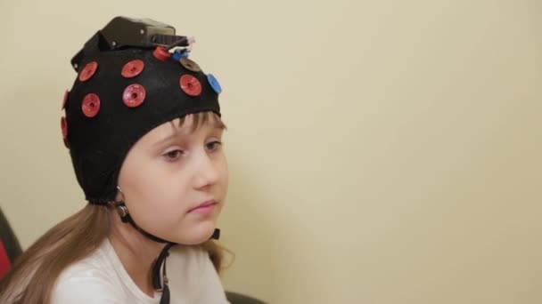 Préparation d'une analyse EEG du cerveau dans le bureau des médecins. Installation d'un dispositif d'examen électroencéphalographique d'une fille. — Video