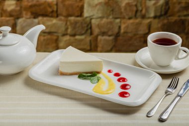 Lokantada reçelli beyaz tabakta taze peynirli kek..