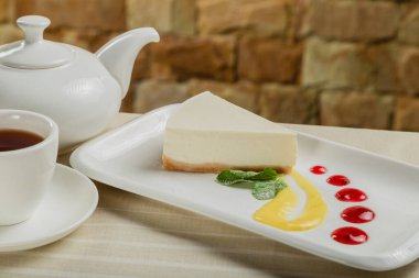 Lokantada reçelli beyaz tabakta taze peynirli kek..