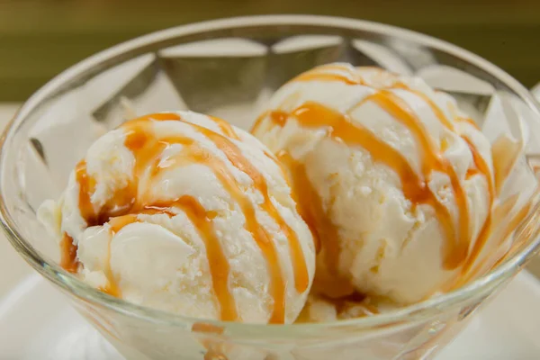 White ice cream in a glass glass with caramel.