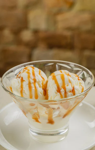 White ice cream in a glass glass with caramel.