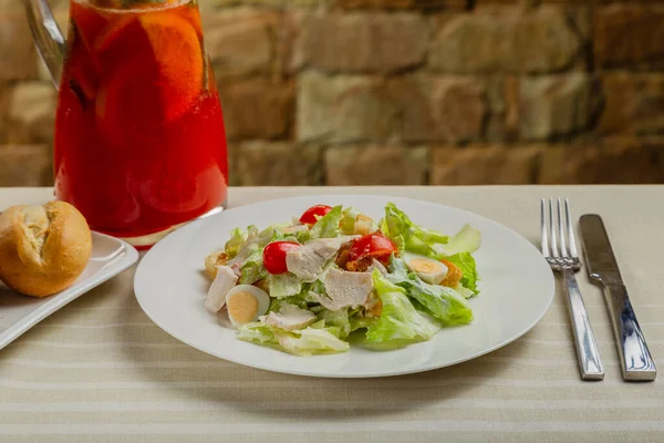 Свежий салат Цезарь в белой тарелке на столе. — стоковое фото