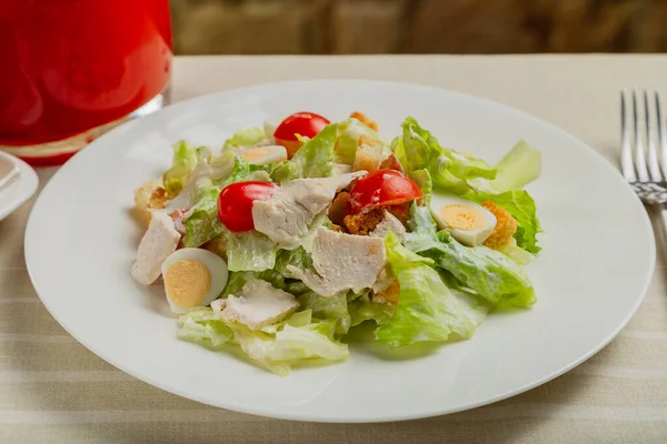 Φρέσκια σαλάτα caesar σε λευκό πιάτο στο τραπέζι. — Φωτογραφία Αρχείου