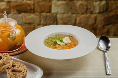 Taze sebzeli çorba, et ve yumurta beyaz tabakta..