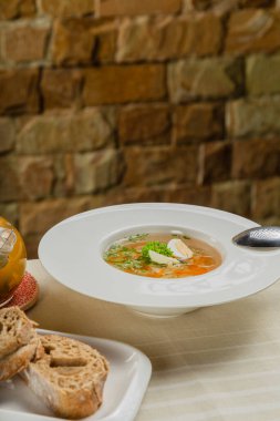 Taze sebzeli çorba, et ve yumurta beyaz tabakta..