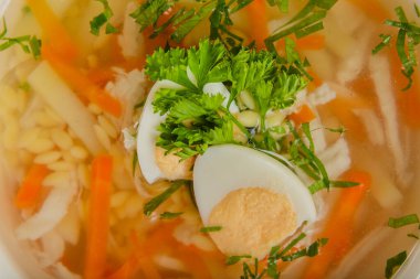 Taze sebzeli çorba, et ve yumurta beyaz tabakta..