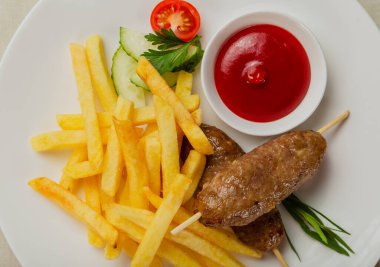 Kızarmış patates ve domates soslu taze kebap..