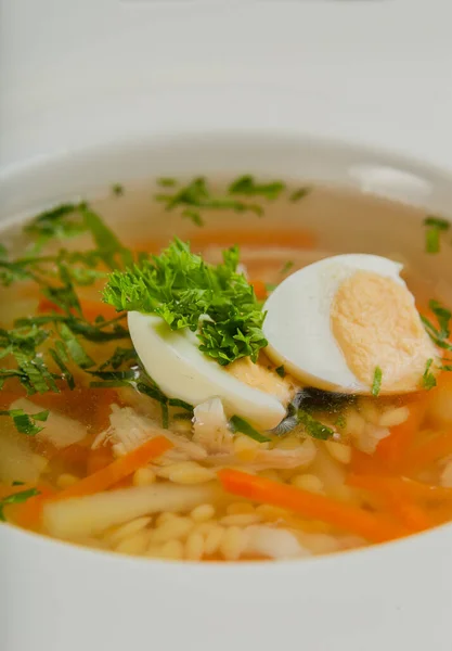 Sopa fresca con verduras, carne y huevos en un plato blanco. — Foto de Stock