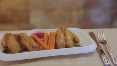 Tabakta sos olan taze kızarmış tavuk kanatları..