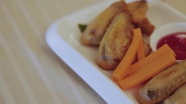 Tabakta sos olan taze kızarmış tavuk kanatları..