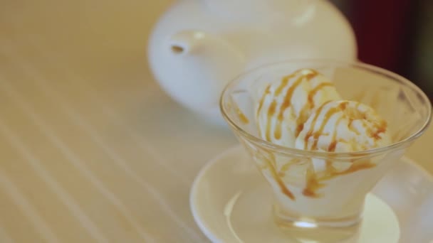 Kaltes frisches Eis mit Karamell im Glas. — Stockvideo