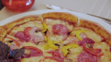 Beyaz tabakta sosisli ve peynirli taze sıcak pizza..