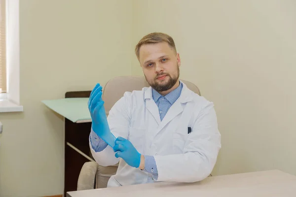 Homme médecin portant des gants en caoutchouc dans le bureau. — Photo