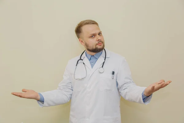 Médico masculino se sorprende contra el fondo de una pared amarilla. —  Fotos de Stock